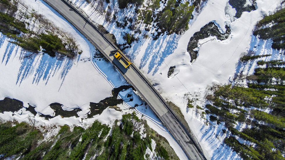 drönarfoto av lastbil på bro i snöigt landskap