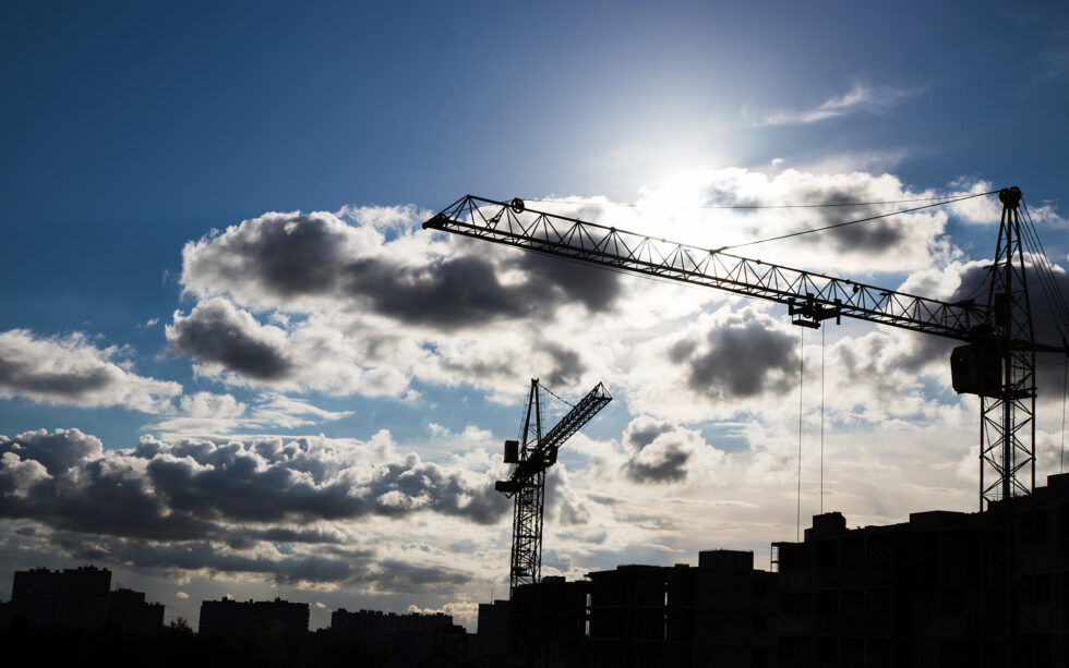 byggkranar mot mörk himmel