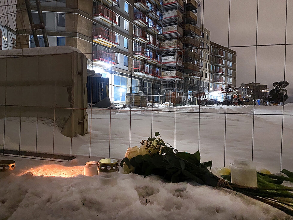 Byggarbetsplatsen där fem personer avled. Blommor och gravljus utanför staketet.