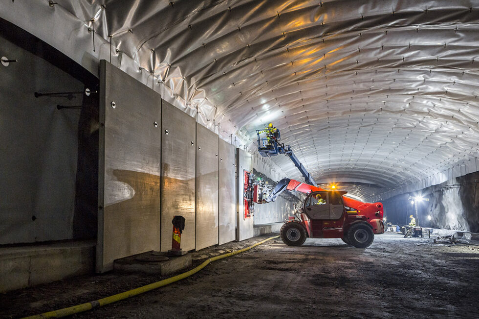 Anläggningsarbete i tunnel, upphängning av väggelement.