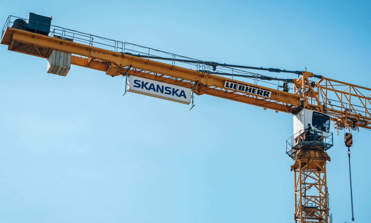 Byggkran med Skanskas logga på en skylt.