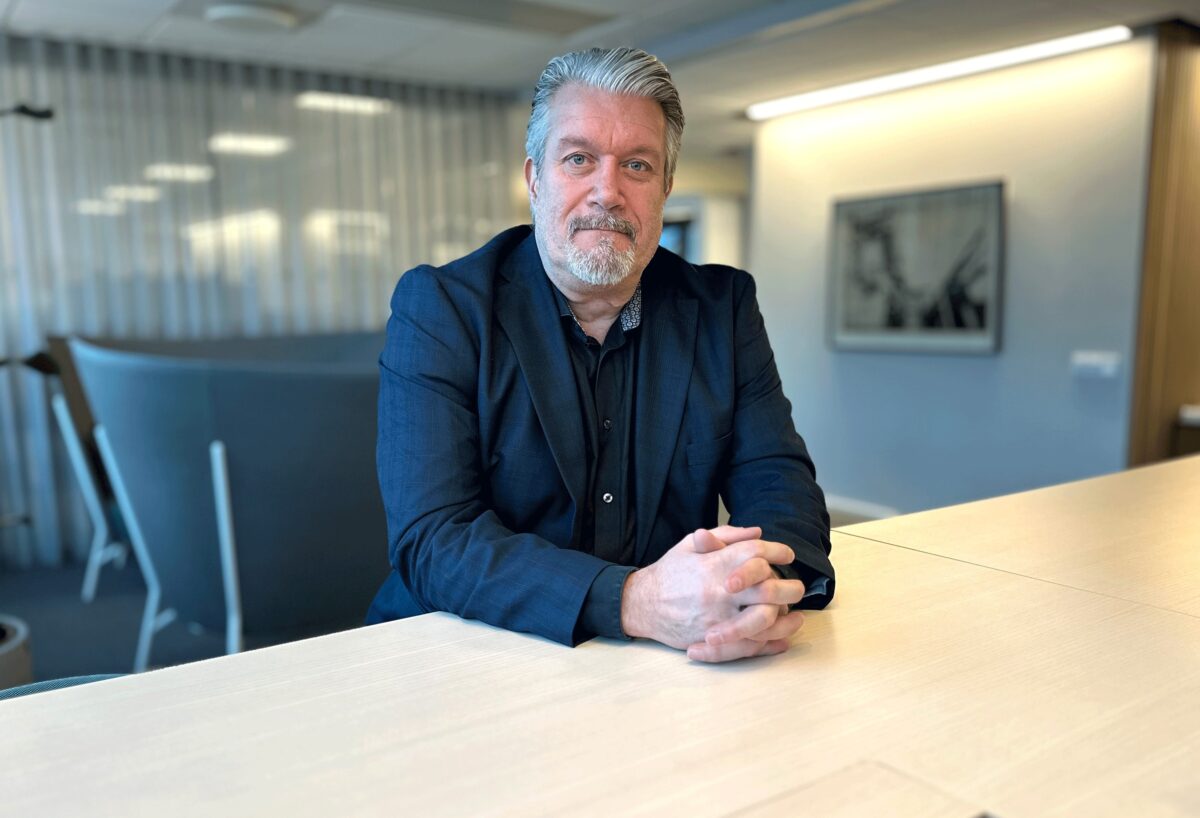 Kostymkläddman som sitter vid ett bord.