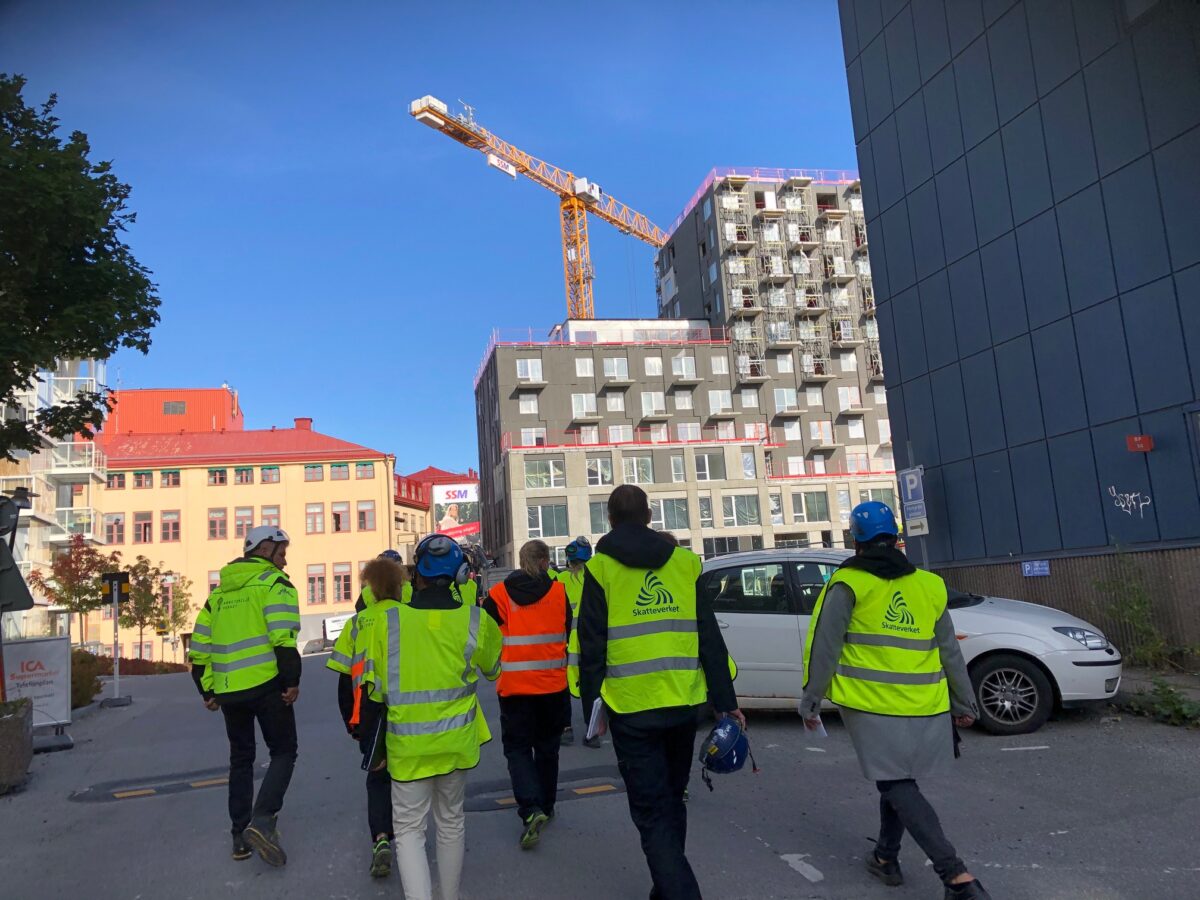 En grupp myndighetskontrollanter i gula västar på en byggarbetsplats. Foto: Arbetsmiljöverket