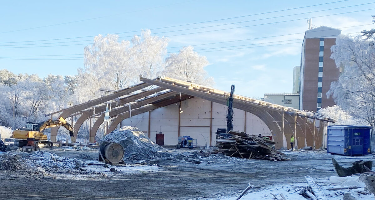 Foto som visar den delvis rivna ishallen, med limträbalkarna fortfarande kvar.