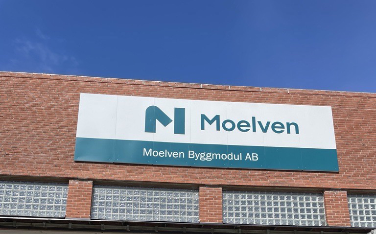 Fabriksfasad med skylt där det står Moelven Byggmodul på