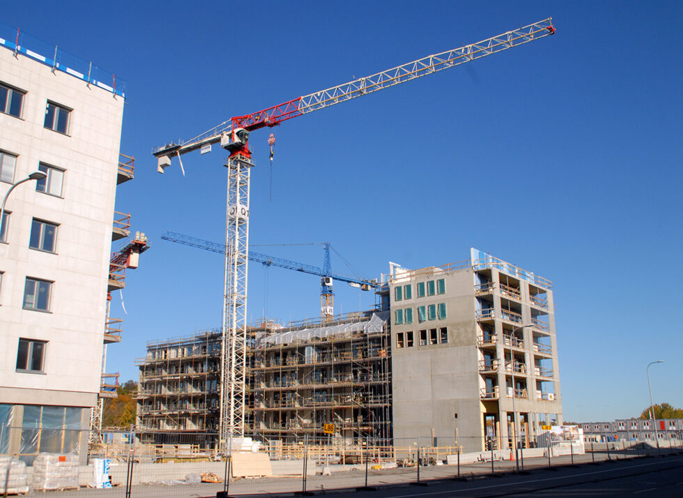 pågående bostadsbyggande med byggkranar utanför ett flervåningshus