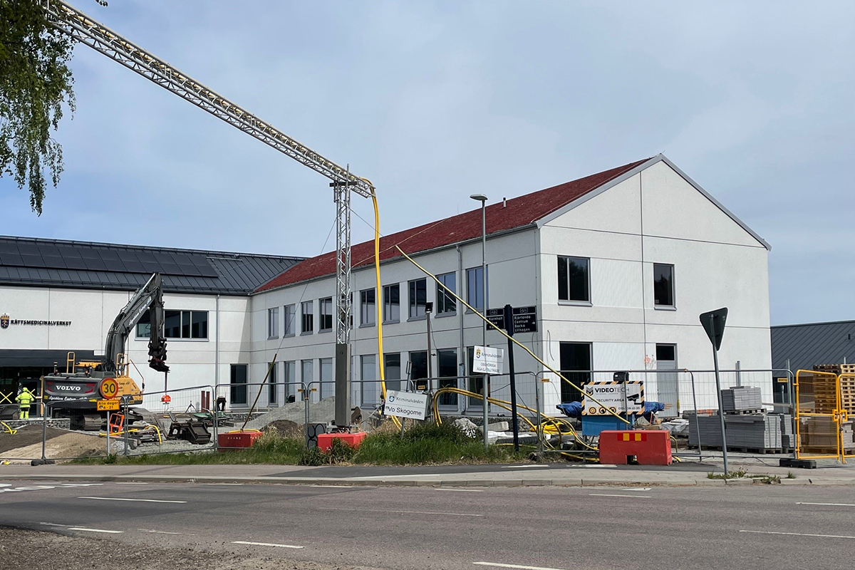 Skogomeanstalten med byggkranar och byggstaket utanför. skanska bygger på uppdrag av Specialfastigheter