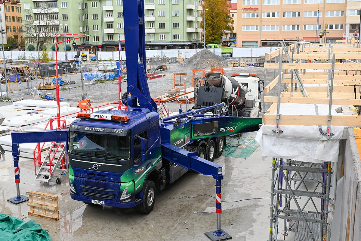 Betongpumpen er malt som et nordlys i blått, grønt og turkis.